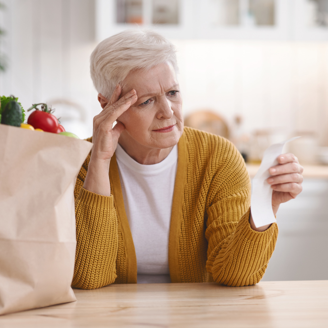 ältere Frau erschrocken über teuere Lebensmittelpreise